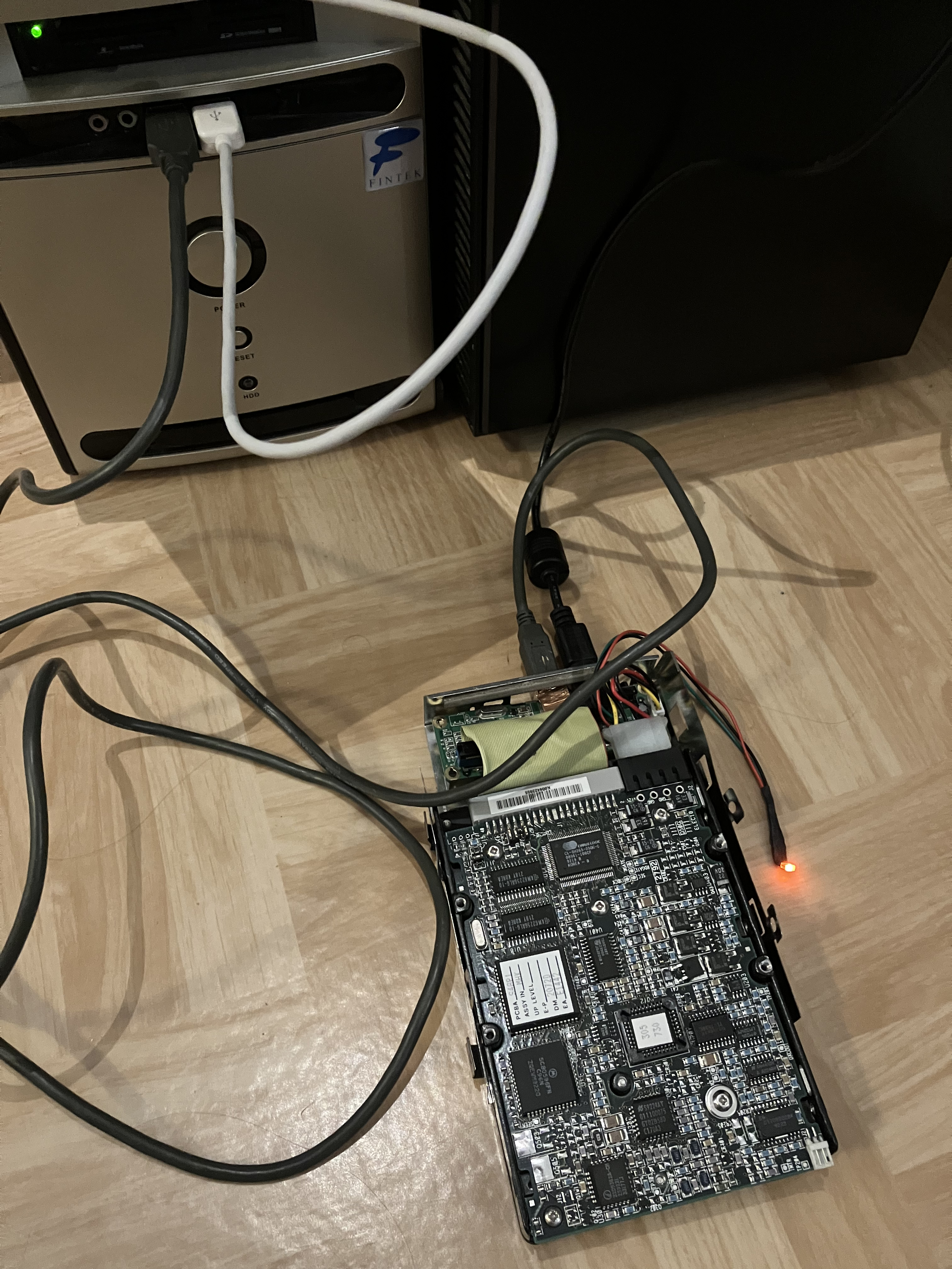 a rather janky IDE–USB adapter built out of a early-2000s external HDD case