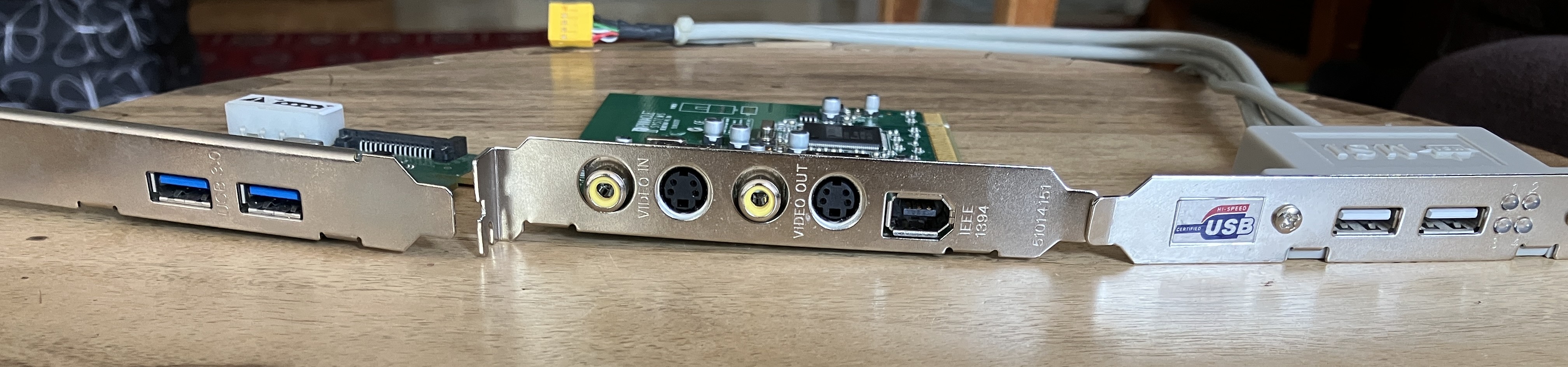 a picture of the three components from the front, showing the composite and S-Video video i/o and the IEEE 1394 connector on the capture card